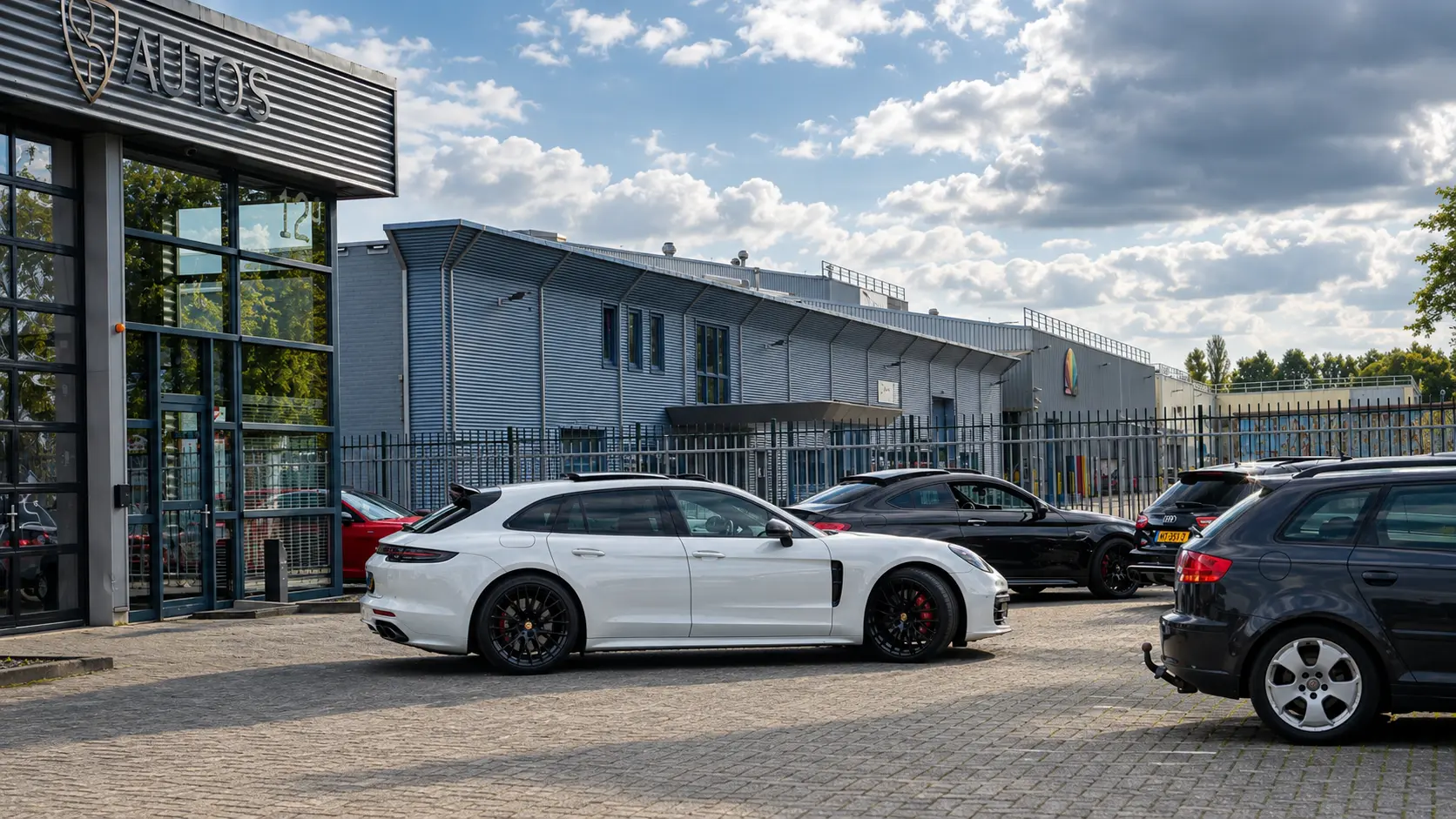Buitenzijde van de showroom van QD AUTO'S in Hoogezand met een Porsche Panamera